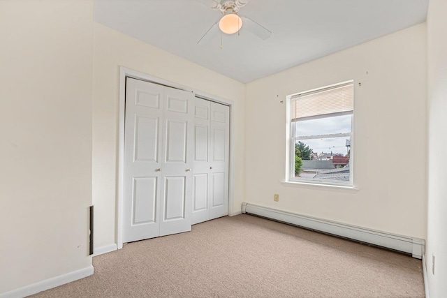 22 King Ave, Yonkers, NY 10704 - unfurnished bedroom featuring a baseboard radiator, light colored carpet, a closet, and ceiling fan