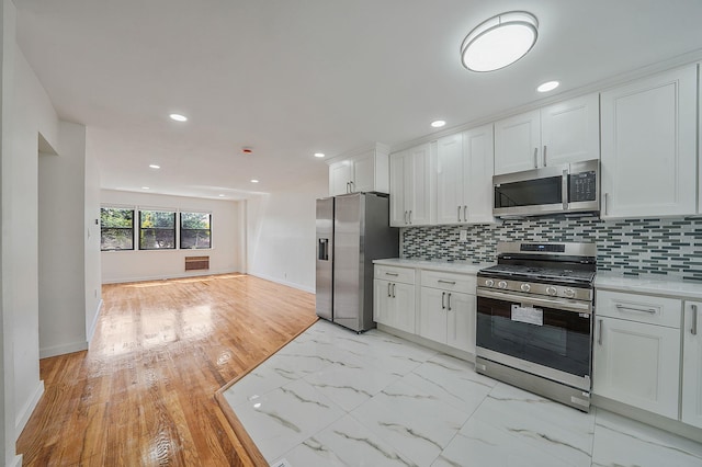 11708A 233rd St, Cambria Heights, NY 11411 - kitchen with appliances with stainless steel finishes, light countertops, white cabinets, backsplash, and recessed lighting