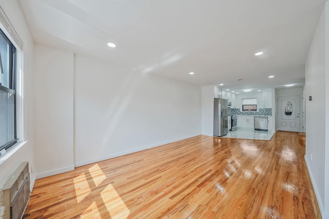 11708A 233rd St, Cambria Heights, NY 11411 - unfurnished living room featuring light wood-type flooring, recessed lighting, and a wall mounted air conditioner