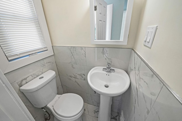 11708A 233rd St, Cambria Heights, NY 11411 - bathroom with tile walls, marble look tiles, and wainscoting