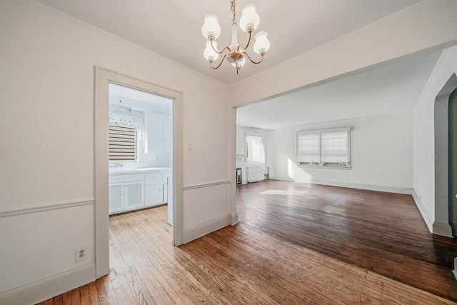 18803 Ilion Ave, Saint Albans, NY 11412 - unfurnished living room featuring a chandelier, hardwood / wood-style floors, and crown molding