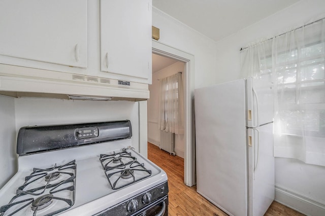 18803 Ilion Ave, Saint Albans, NY 11412 - kitchen with white appliances, under cabinet range hood, light wood-type flooring, ornamental molding, and white cabinets