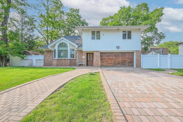 1096 Pearl St, North Woodmere, NY 11581 - split level home with an attached garage, decorative driveway, brick siding, and a gate