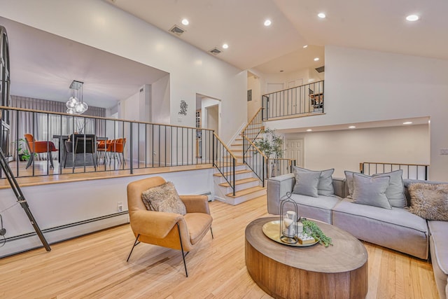 1096 Pearl St, North Woodmere, NY 11581 - living room with wood finished floors, a chandelier, high vaulted ceiling, baseboard heating, and stairway