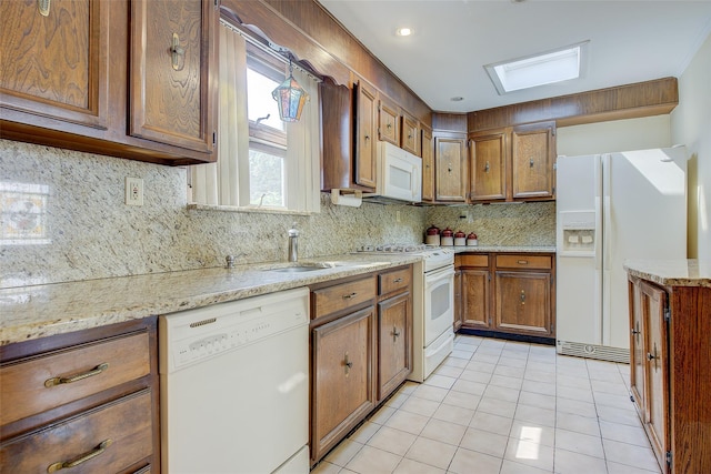 163 15th Dr, Whitestone, NY 11357 - kitchen with white appliances, brown cabinetry, light tile patterned flooring, tasteful backsplash, and light stone counters
