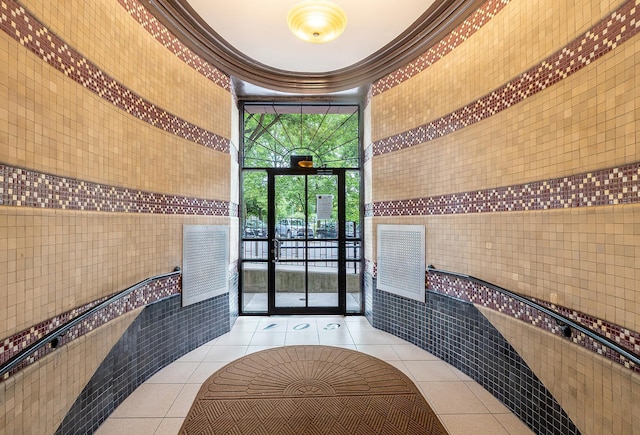 601 Pelham Pkwy N Unit 516, Bronx, NY 10467 - lobby with crown molding, tile walls, a towering ceiling, and a wall of windows