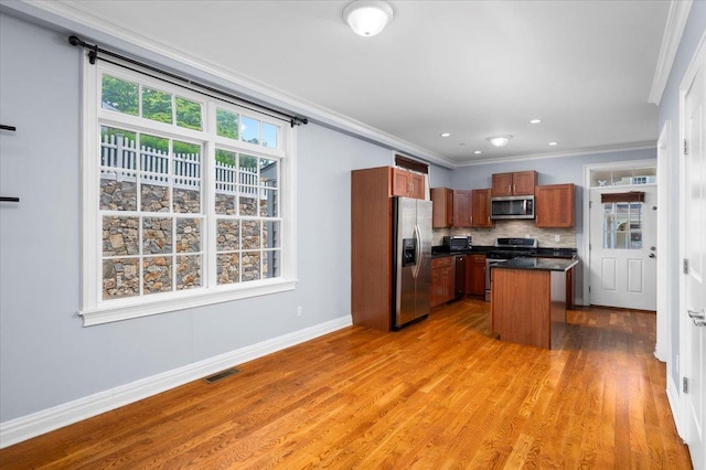 19 Olivia St Unit 5, Port Chester, NY 10573 - kitchen featuring stainless steel appliances, dark countertops, light wood-type flooring, tasteful backsplash, and crown molding