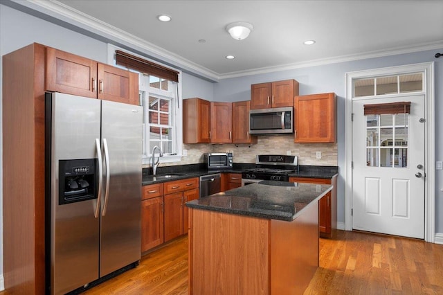 19 Olivia St Unit 5, Port Chester, NY 10573 - kitchen featuring stainless steel appliances, ornamental molding, tasteful backsplash, light wood-style floors, and a kitchen island