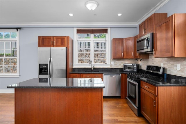 19 Olivia St Unit 5, Port Chester, NY 10573 - kitchen with stainless steel appliances, ornamental molding, a kitchen island, tasteful backsplash, and light wood-type flooring