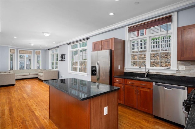 19 Olivia St Unit 5, Port Chester, NY 10573 - kitchen with stainless steel appliances, crown molding, light wood-type flooring, a kitchen island, and dark stone countertops