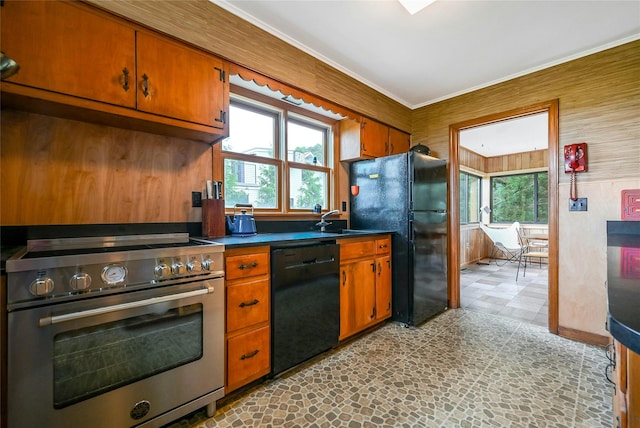 103 Harbor Beach Rd, Miller Place, NY 11764 - kitchen with black appliances, healthy amount of natural light, brown cabinetry, dark countertops, and wood walls