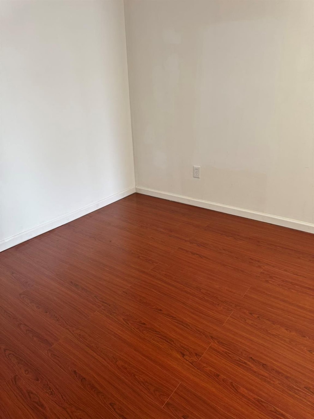 1811 123rd St Unit 4F, College Point, NY 11356 - empty room with dark wood finished floors and baseboards