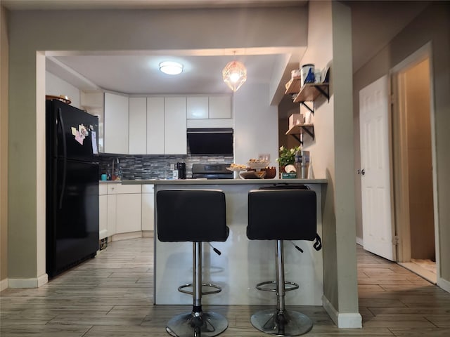 240-02 70th Ave Unit 1C, Douglaston, NY 11362 - kitchen featuring freestanding refrigerator, light wood-style floors, backsplash, stainless steel range with electric stovetop, and white cabinetry