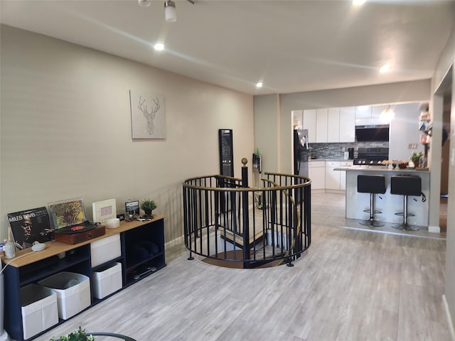 240-02 70th Ave Unit 1C, Douglaston, NY 11362 - kitchen with white cabinets, range, freestanding refrigerator, light wood-style flooring, and tasteful backsplash