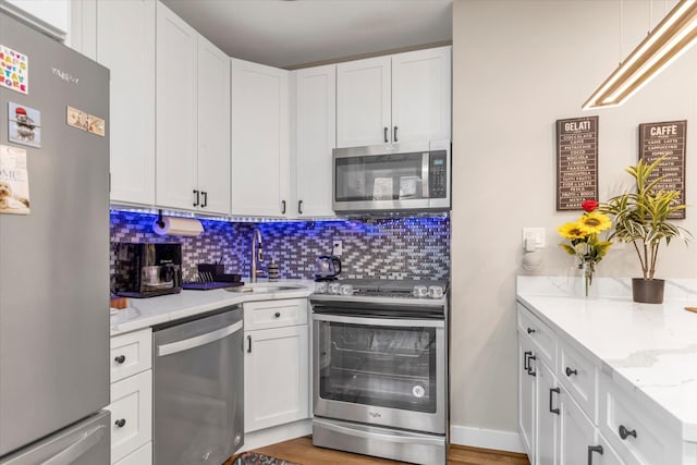 160-15 Powells Cove Blvd Unit B103, Beechhurst, NY 11357 - kitchen with stainless steel appliances, tasteful backsplash, white cabinetry, and light stone countertops