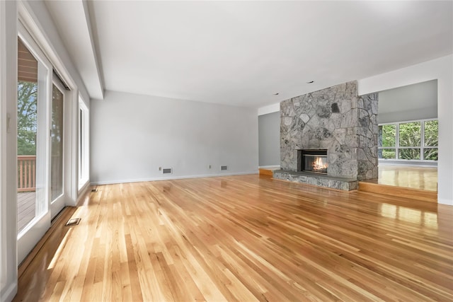 94 Hirst Rd, Briarcliff Manor, NY 10510 - unfurnished living room featuring light wood-style flooring and a stone fireplace