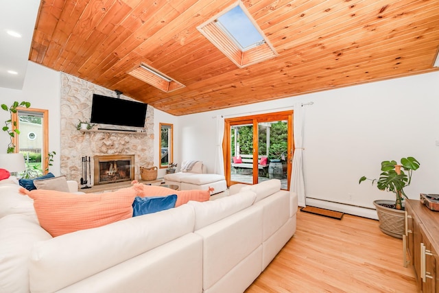 27 Dorchester Rd, Smithtown, NY 11787 - living room with a skylight, a baseboard heating unit, vaulted ceiling, a stone fireplace, and light wood finished floors