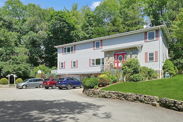 49 Nanny Hagen Rd, Thornwood, NY 10594 - view of front of house featuring an attached garage, stone siding, and a front yard
