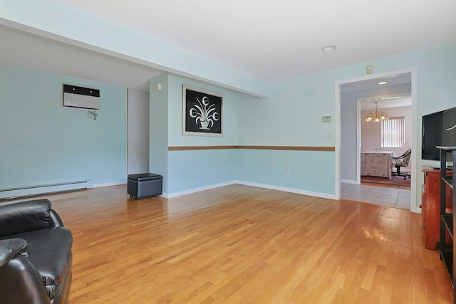 49 Nanny Hagen Rd, Thornwood, NY 10594 - living area featuring a chandelier, light wood finished floors, an AC wall unit, and a baseboard heating unit
