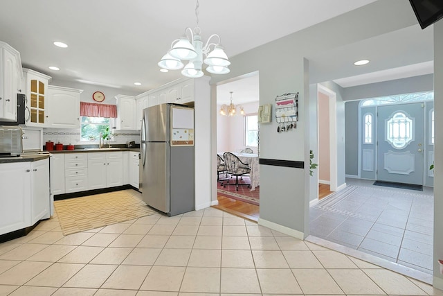 49 Nanny Hagen Rd, Thornwood, NY 10594 - kitchen with stainless steel appliances, a chandelier, dark countertops, white cabinets, and plenty of natural light