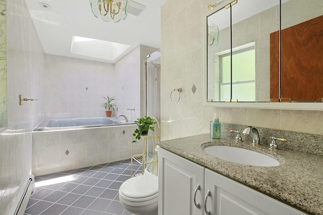 49 Nanny Hagen Rd, Thornwood, NY 10594 - bathroom featuring a baseboard radiator, a skylight, vanity, tile patterned floors, and a relaxing tiled tub