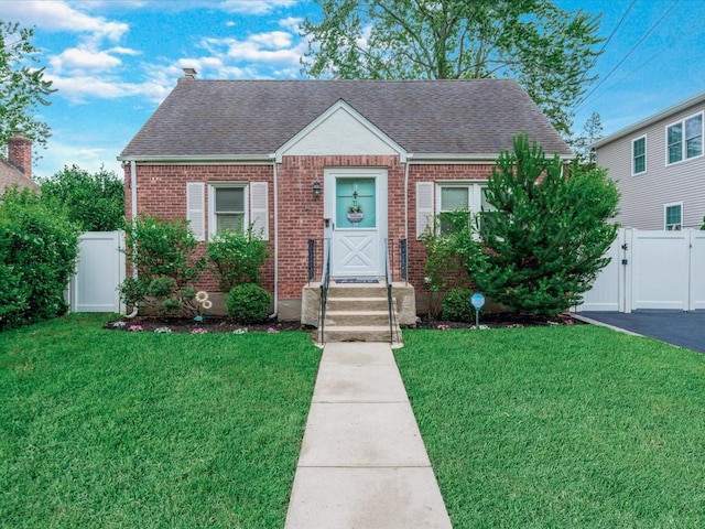 71 Van Nostrand Ave, North Merrick, NY 11566 - view of front facade with a gate, brick siding, and roof with shingles