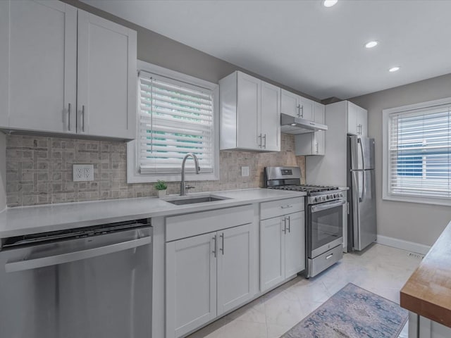 71 Van Nostrand Ave, North Merrick, NY 11566 - kitchen with stainless steel appliances, under cabinet range hood, light countertops, white cabinetry, and recessed lighting