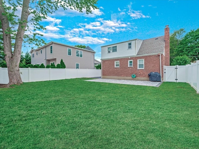 71 Van Nostrand Ave, North Merrick, NY 11566 - back of property featuring a gate, a patio area, brick siding, a fenced backyard, and a chimney