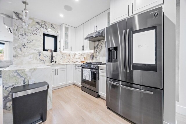 2539 48th St, Astoria, NY 11103 - kitchen featuring stainless steel appliances, under cabinet range hood, glass insert cabinets, backsplash, and white cabinets