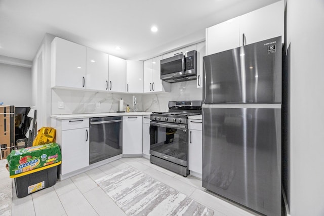 2539 48th St, Astoria, NY 11103 - kitchen featuring stainless steel appliances, white cabinets, light tile patterned flooring, light countertops, and backsplash