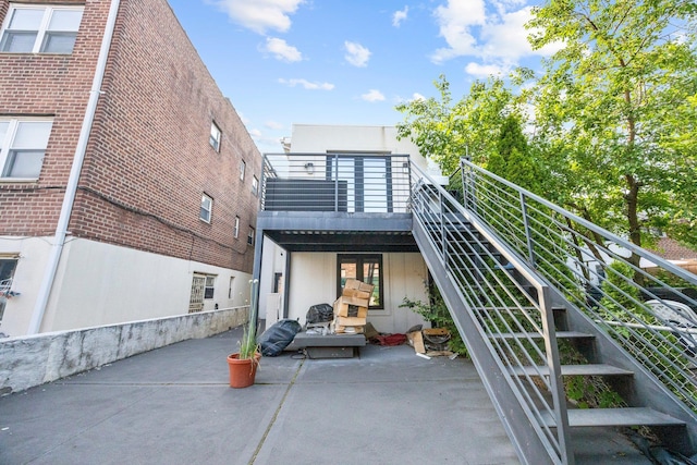 2539 48th St, Astoria, NY 11103 - rear view of house featuring stairway, a patio, and a balcony