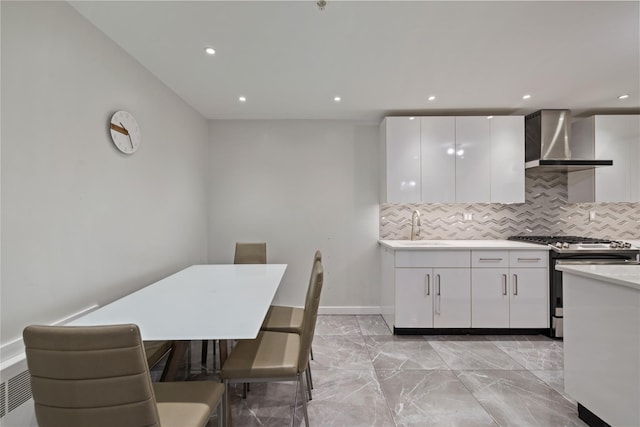 487 W Central Ave Unit 112, Spring Valley, NY 10977 - kitchen featuring wall chimney range hood, stainless steel range with gas stovetop, tasteful backsplash, white cabinetry, and recessed lighting