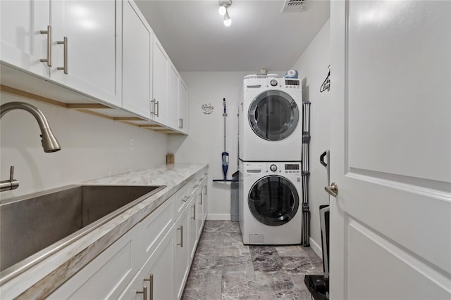 487 W Central Ave Unit 112, Spring Valley, NY 10977 - laundry room featuring stacked washing machine and dryer, cabinet space, and light marble finish flooring