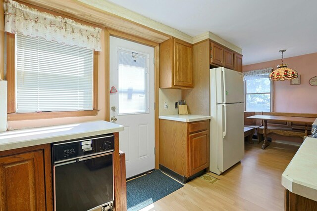 328 Willis Ave, Hawthorne, NY 10532 - kitchen with freestanding refrigerator, light wood-style floors, light countertops, brown cabinetry, and hanging light fixtures