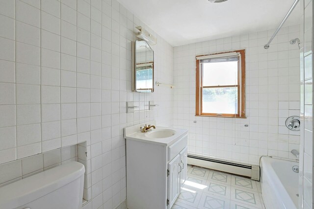 328 Willis Ave, Hawthorne, NY 10532 - bathroom featuring baseboard heating, tile walls, vanity, and shower / bathtub combination