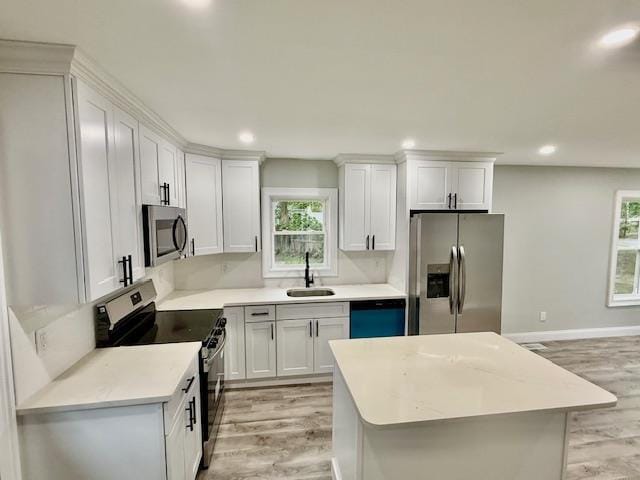 49 Heston Rd, Shirley, NY 11967 - kitchen with appliances with stainless steel finishes, light wood finished floors, plenty of natural light, recessed lighting, and white cabinetry