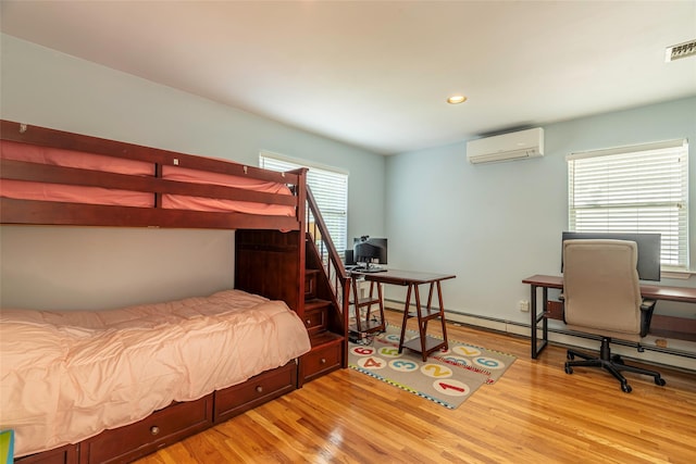 53 Vista Hill Rd, Great Neck, NY 11021 - bedroom featuring an AC wall unit, light wood finished floors, an office area, recessed lighting, and a baseboard radiator