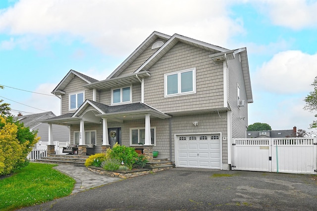 250 33rd St, Lindenhurst, NY 11757 - view of front of home with a porch, an attached garage, a gate, and asphalt driveway