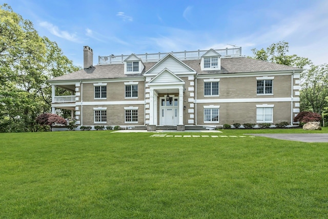 12 Orient Ave, Northport, NY 11768 - view of front facade with a chimney, a front yard, a balcony, and roof with shingles