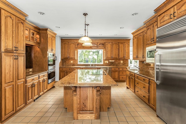 12 Orient Ave, Northport, NY 11768 - kitchen featuring built in appliances, a center island, light tile patterned floors, brown cabinets, and recessed lighting