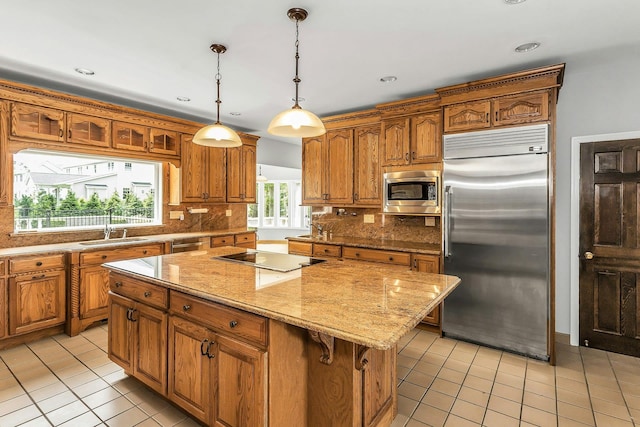 12 Orient Ave, Northport, NY 11768 - kitchen with built in appliances, light tile patterned flooring, a center island, backsplash, and brown cabinets