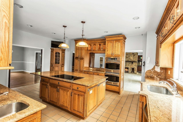 12 Orient Ave, Northport, NY 11768 - kitchen with stainless steel double oven, light tile patterned flooring, light stone countertops, a center island, and hanging light fixtures