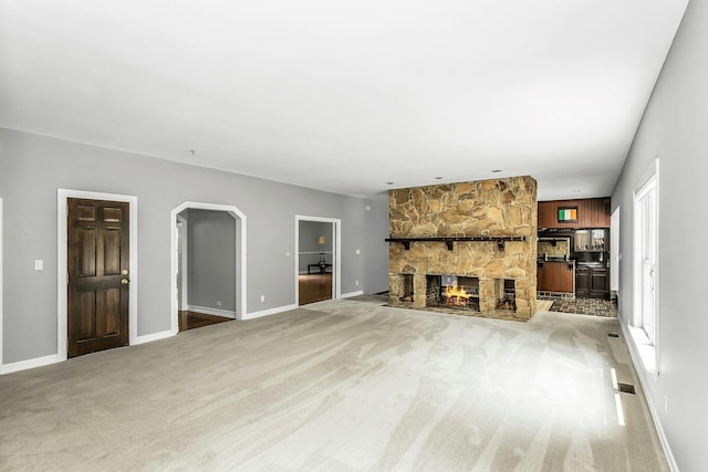 12 Orient Ave, Northport, NY 11768 - unfurnished living room with light colored carpet, arched walkways, and a fireplace