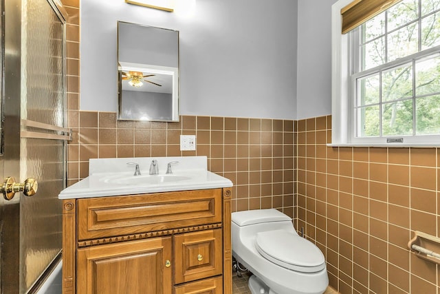 12 Orient Ave, Northport, NY 11768 - bathroom with tile walls, vanity, a shower with door, a ceiling fan, and wainscoting