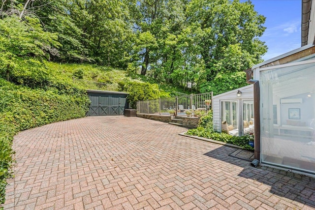 50 Shore Rd, Cold Spring Harbor, NY 11724 - view of patio with a storage shed and view of wooded area
