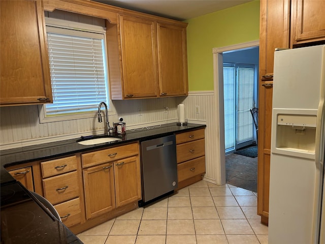 42 Columbia St, Poughkeepsie, NY 12601 - kitchen featuring white fridge with ice dispenser, stainless steel dishwasher, wainscoting, light tile patterned flooring, and brown cabinetry