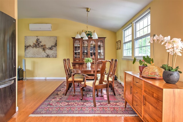 3 Twig Ct, East Setauket, NY 11733 - dining space featuring a wall mounted AC, vaulted ceiling, and wood finished floors