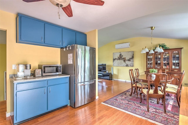 3 Twig Ct, East Setauket, NY 11733 - kitchen featuring blue cabinets, stainless steel appliances, an AC wall unit, light wood finished floors, and lofted ceiling