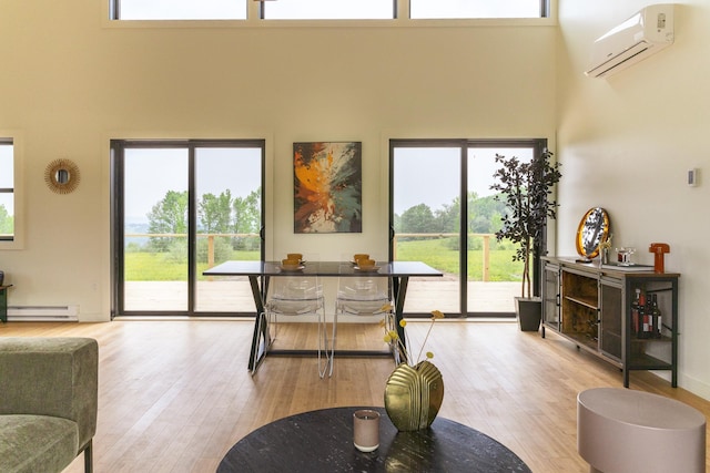 612 Beechwoods Rd, Callicoon, NY 12723 - living area featuring a wall mounted AC, a high ceiling, baseboard heating, and light wood finished floors