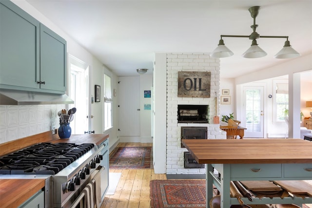132 Decker, Ancram, NY 12502 - kitchen with butcher block countertops, high end stainless steel range oven, light wood-style flooring, a fireplace, and plenty of natural light